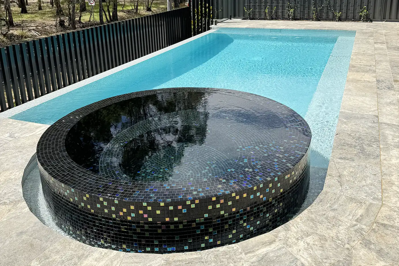 Elevated spa with 360 degree infinity spa edge finished in black pearl tiles that shimmy in sunlight. Elevated spa with 360 degree infinity spa edge finished in black pearl tiles that shimmy in sunlight.