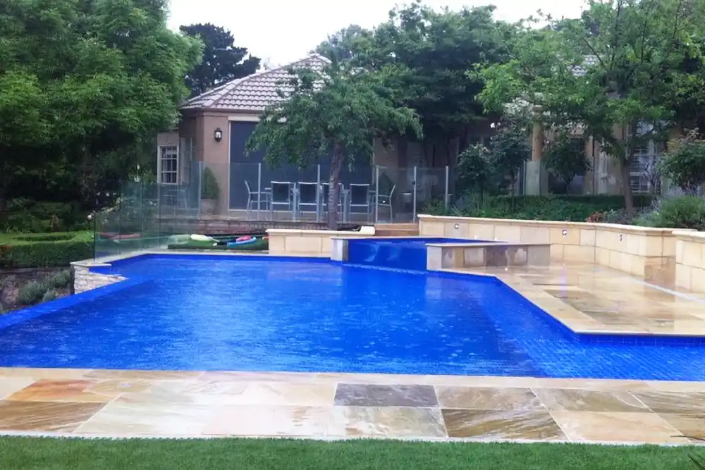 Backyard resort with raised spa overlooking tennis court with infinity edge pool Backyard resort with raised spa overlooking tennis court with infinity edge pool with natural feature the rain